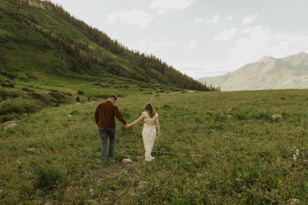 Couple taking destination engagement photos in Crested Butte Colorado