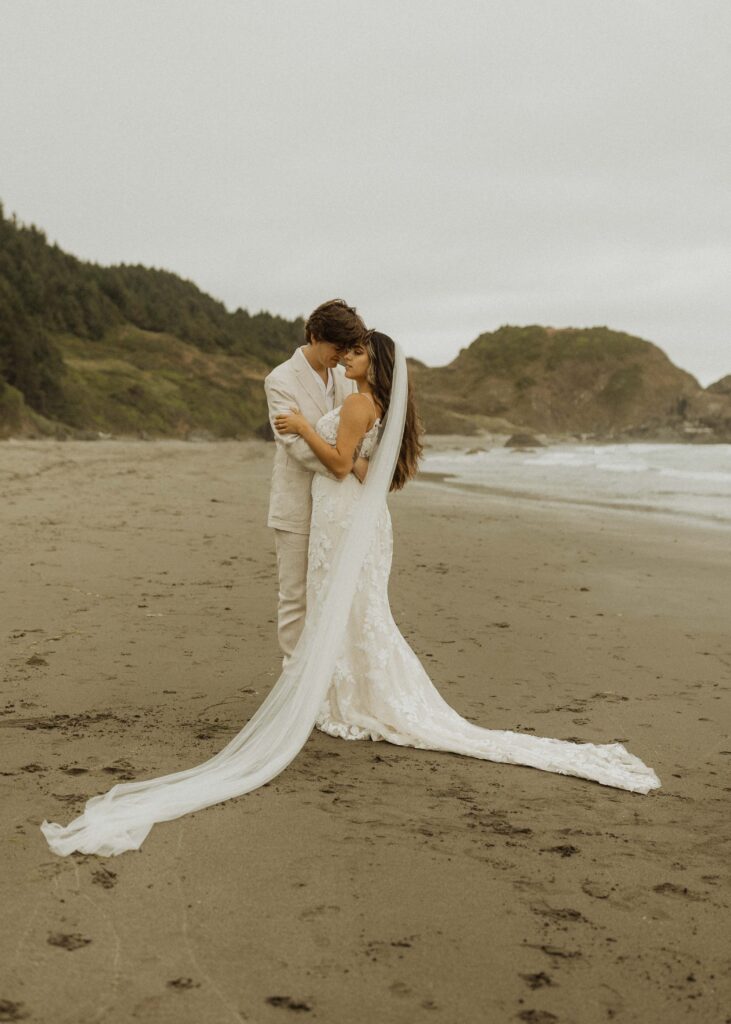bride and groom taking photos during their brookings oregon beach elopement