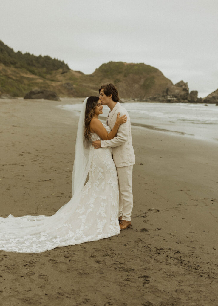 bride and groom taking photos during their brookings oregon beach elopement
