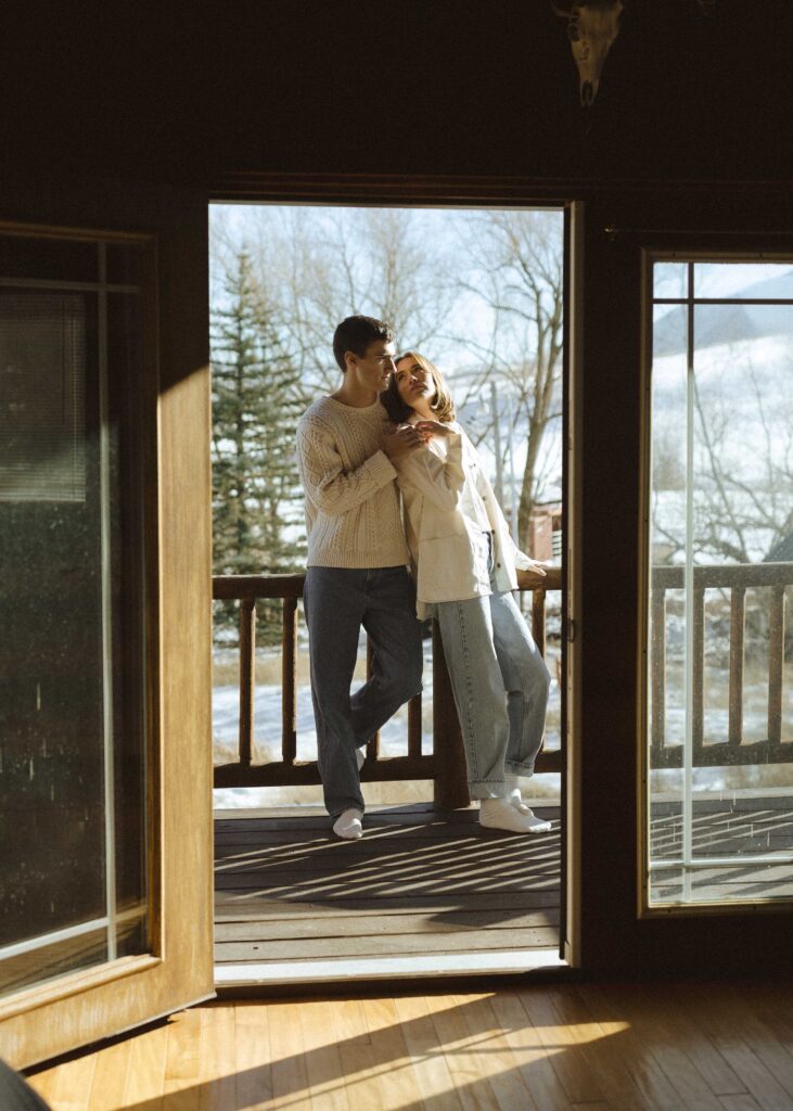 couple taking their engagement photos in a log cabin
