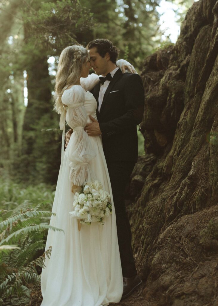 couple taking photos in the redwoods for their luxury elopement 
