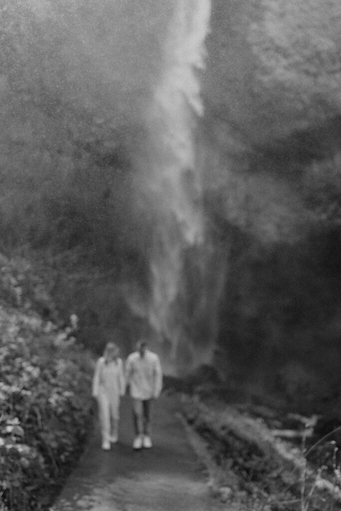 couple walking at their waterfall engagement photos