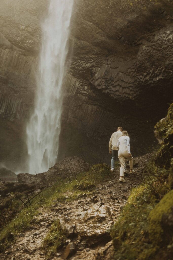 couple walking at their waterfall engagement photos