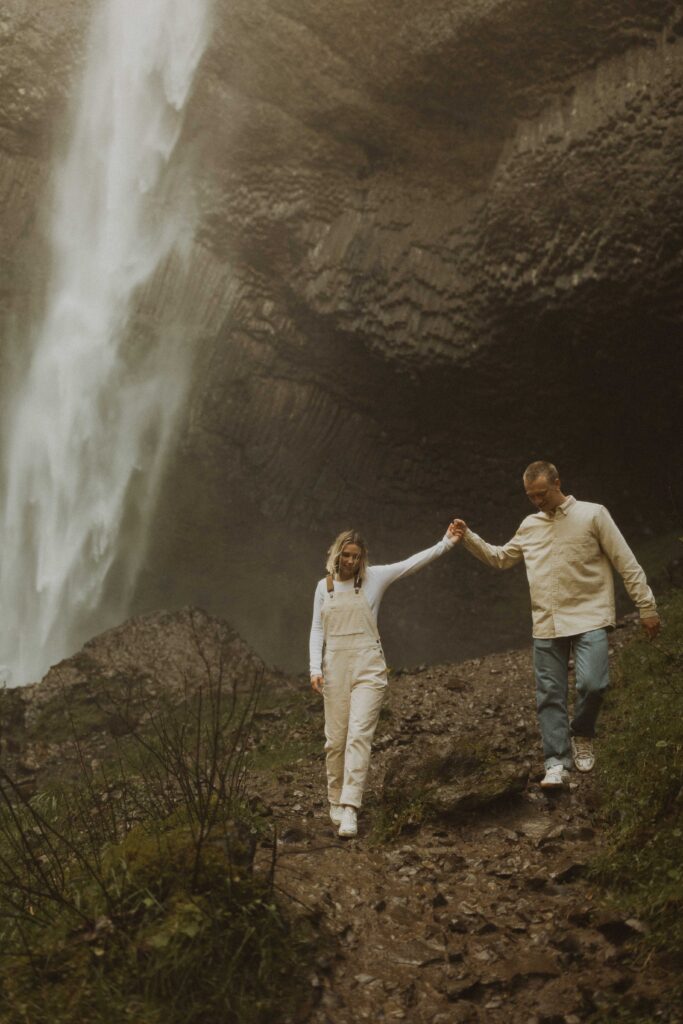couple walking doing their waterfall engagement photos