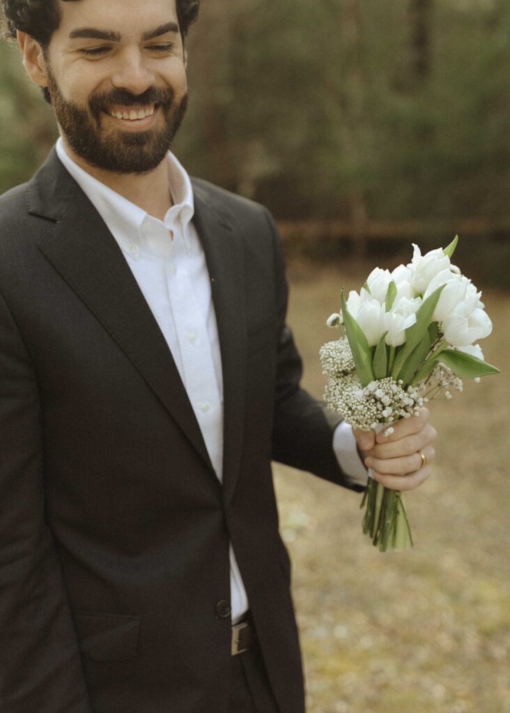 groom carrying brides flowers at Great Smoky Mountains National Park