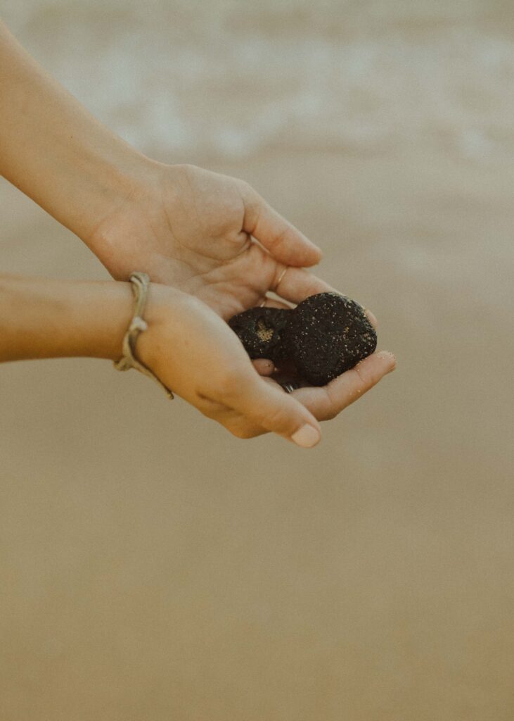 girl holding a rock that she found on the beach at her kauai couples session 