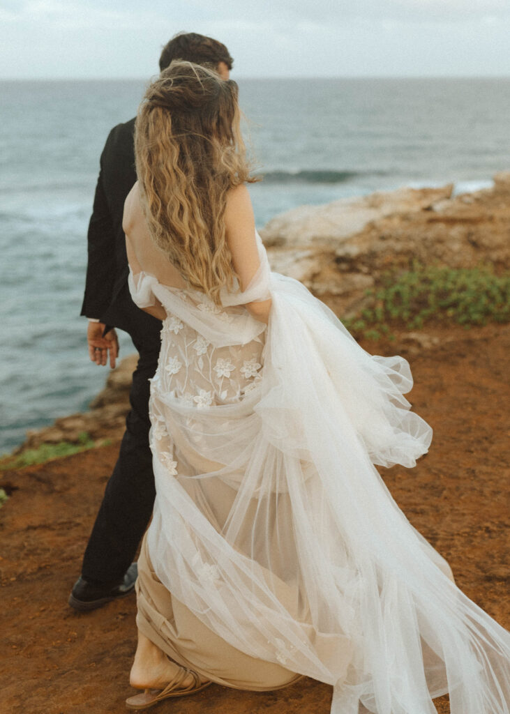 couple walking on the cliffside for their wedding 