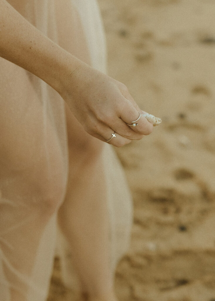 bride picking up shells at her tunnels beach wedding