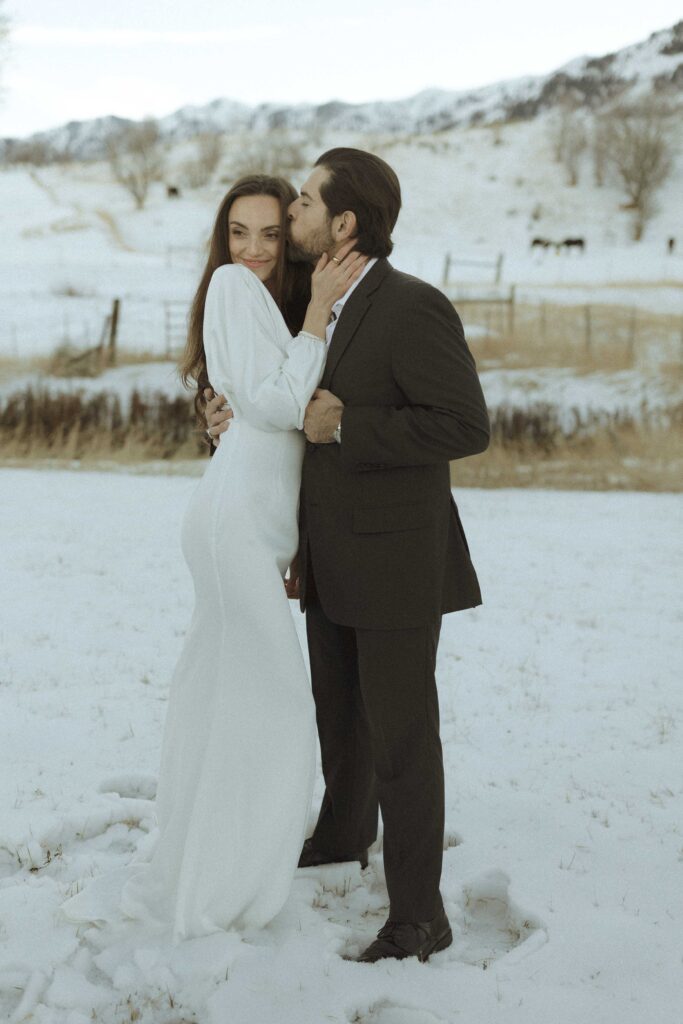 couple taking photos in the snow for their winter elopement 