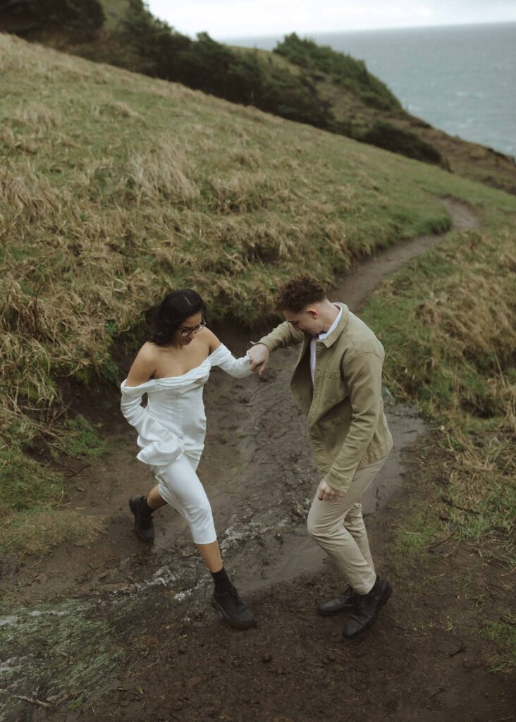 couple walking for their Oregon cliffside elopement 