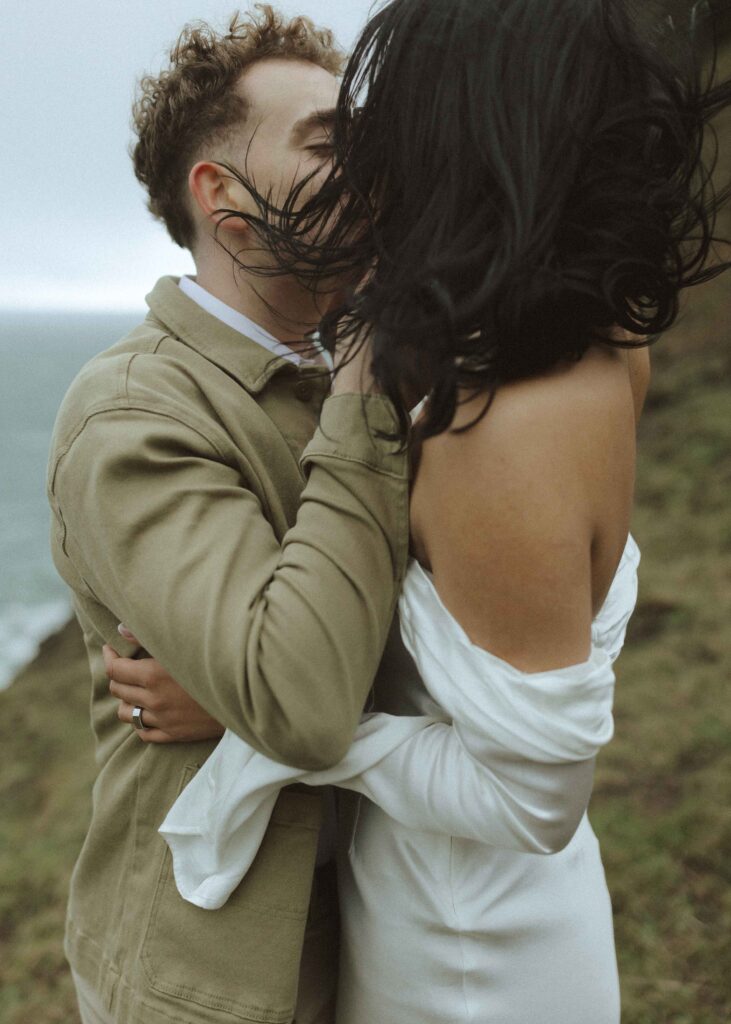 couple taking photos for their Oregon cliffside elopement 