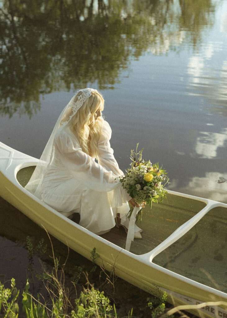 bride and groom taking photos at their canoe elopement 