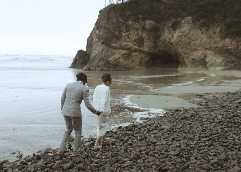 couple walking the beach for their hug point elopement 