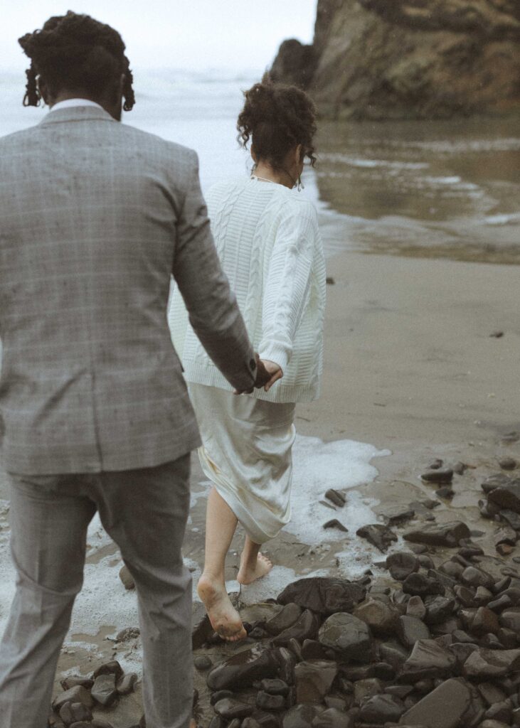 couple walking the beach for their hug point elopement 