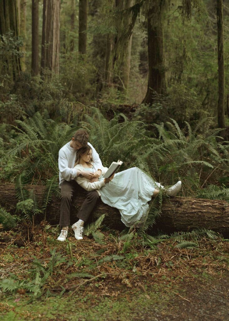 couple reading a book during their redwoods engagement photos