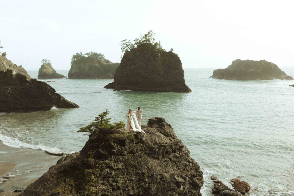 couple taking photos at the beach for their Oregon wedding 