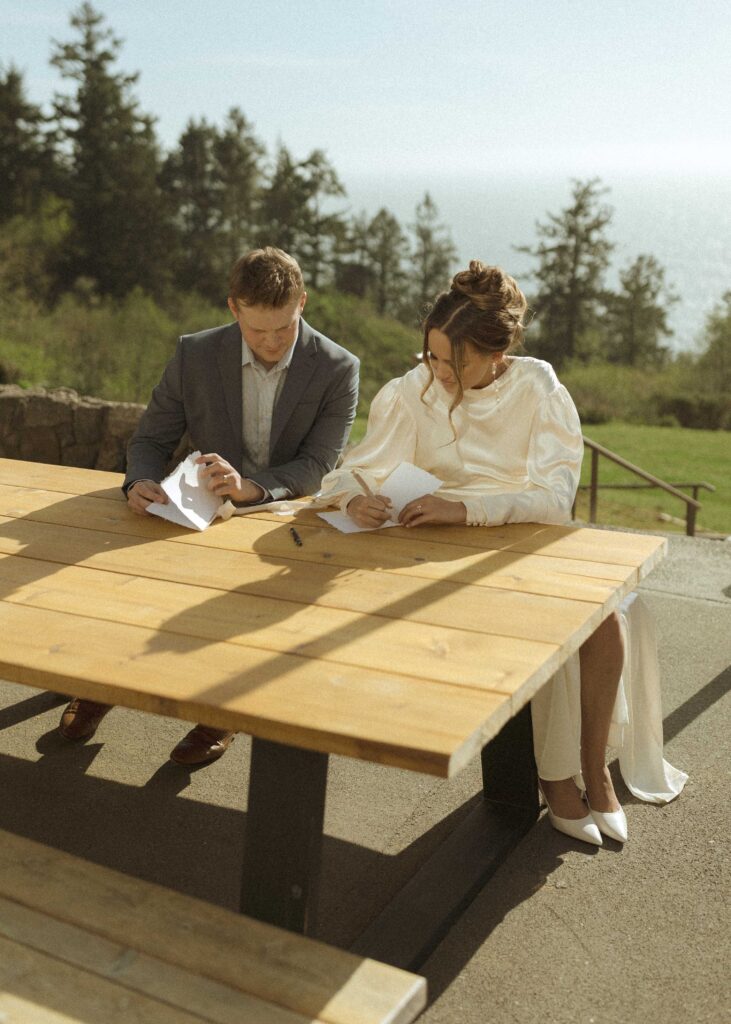 bride and groom writing vows for their crook point elopement 
