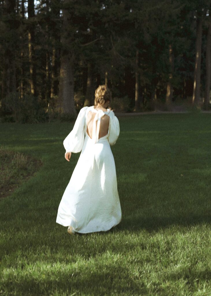 bride walking in the grass after her crook point elopement 