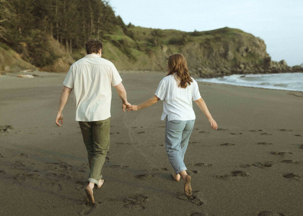 couple walking on the beach for their oregon couples photos 