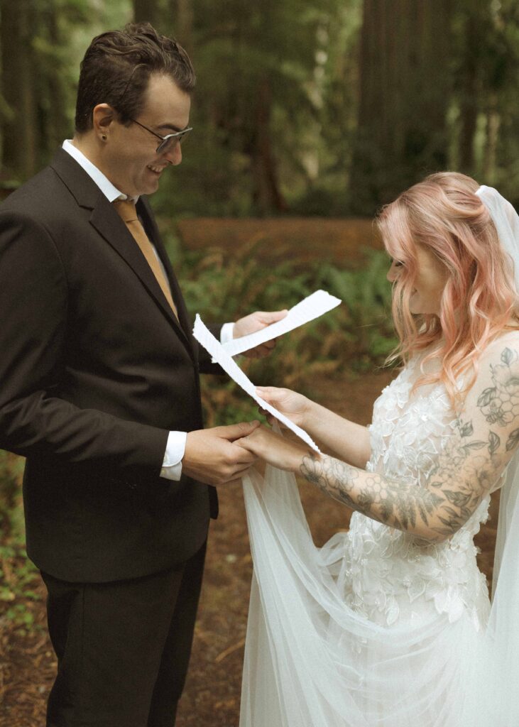 bride and groom reading their vows for their forest elopement 