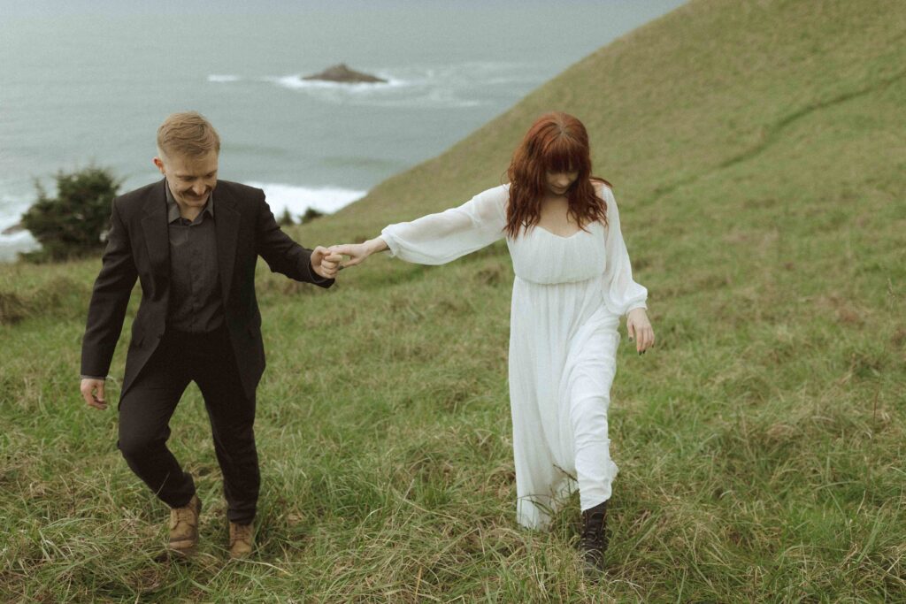 couple walking on the cliffside for their oregon elopement 