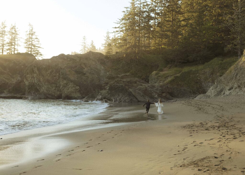 couple walking on the beach for their oregon elopement 