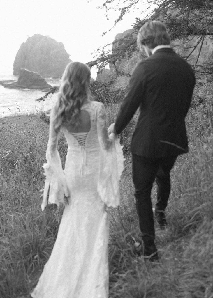 couple taking photos on the beach for their Redwoods Oregon elopement 