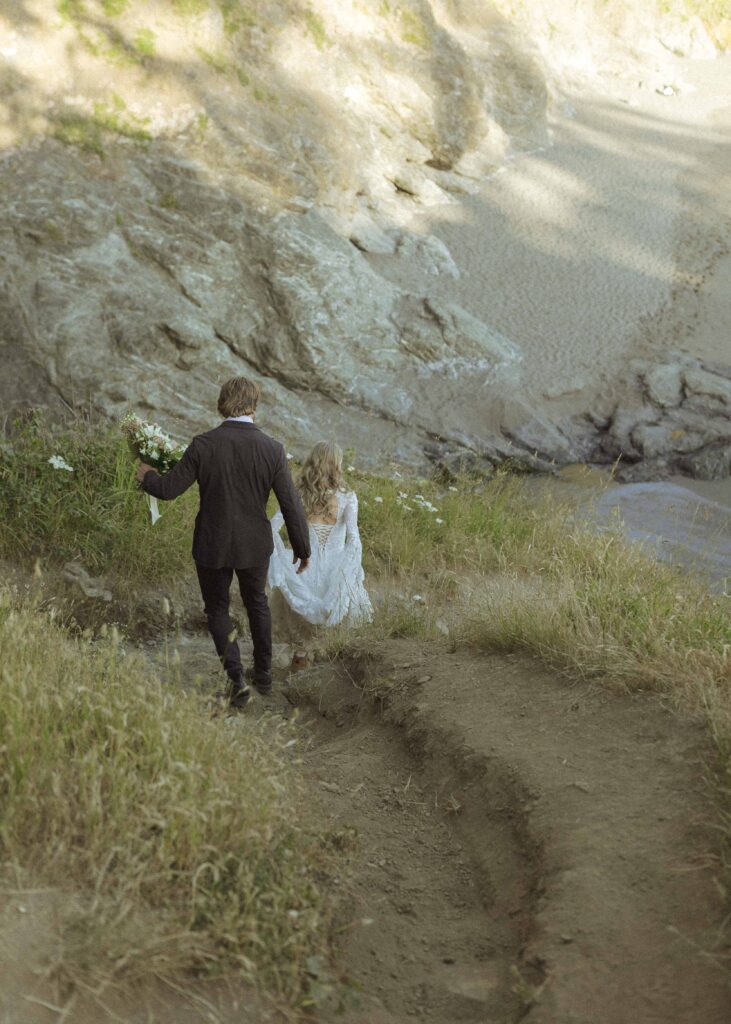 couple taking photos on the beach for their Redwoods Oregon elopement 