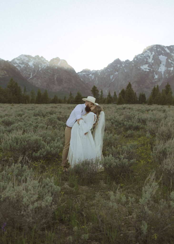 couple taking sunset photos for their mountain view turnout wedding