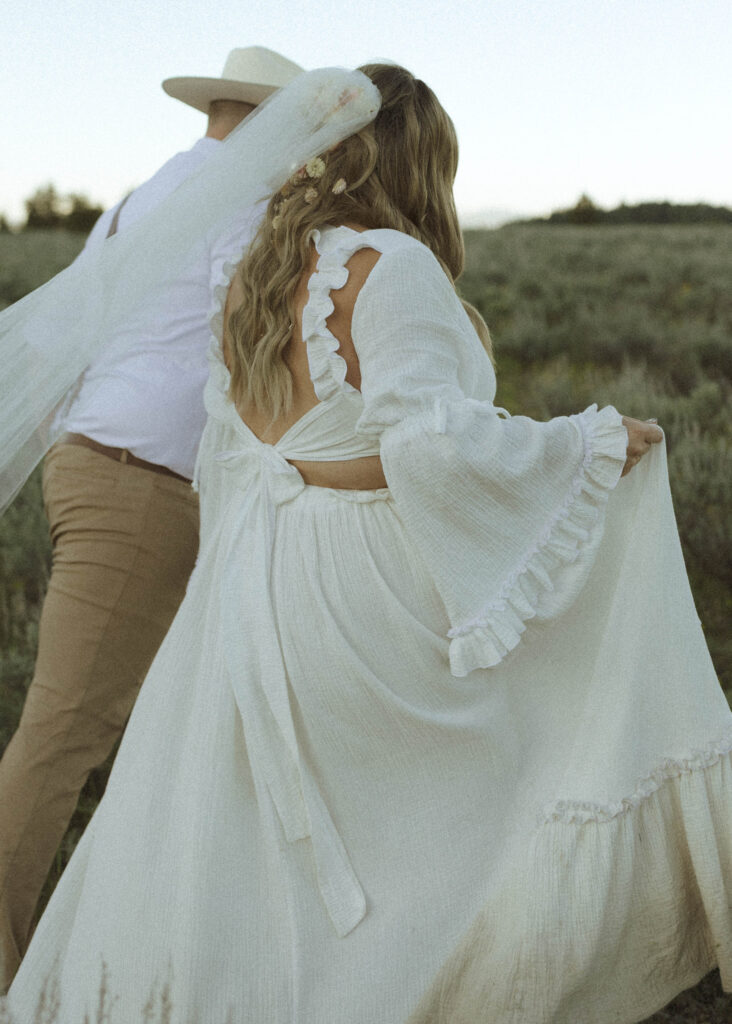 couple walking in the grass for their mountain view turnout wedding 