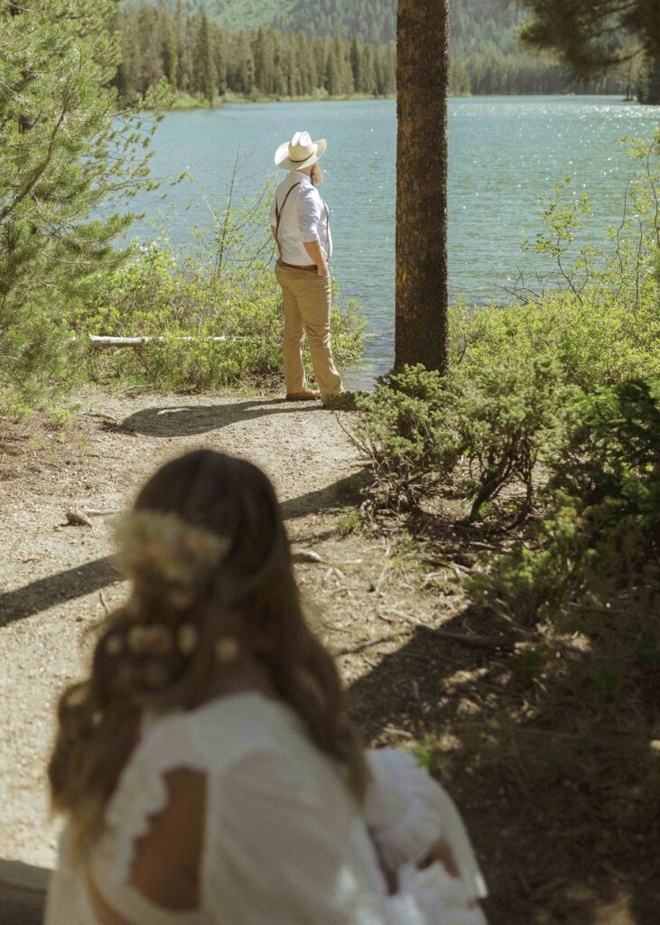 couple taking photos at a lake before their mountain view turnout wedding 