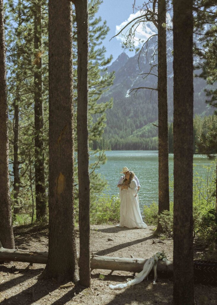 couple taking photos at a lake before their mountain view turnout wedding 