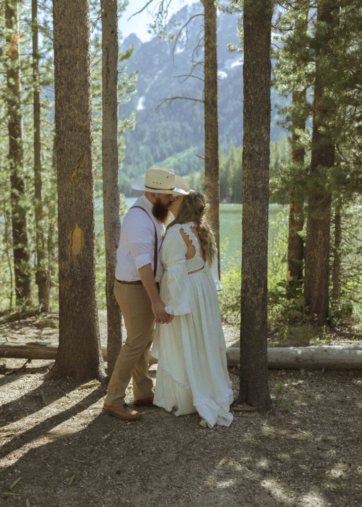 couple taking photos at a lake before their mountain view turnout wedding 