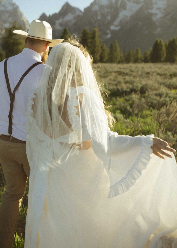 couple walking in the grass for their mountain view turnout wedding 