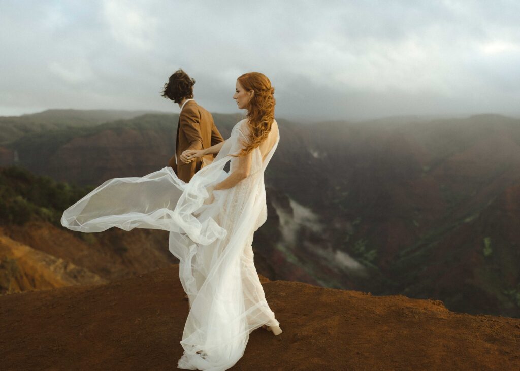 couple walking on waimea canyon for their Kauai elopement 