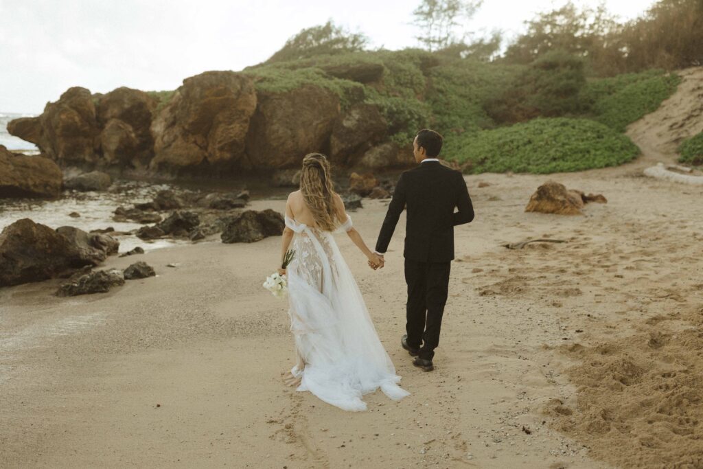 couple walking on the beach for their Kauai elopement 