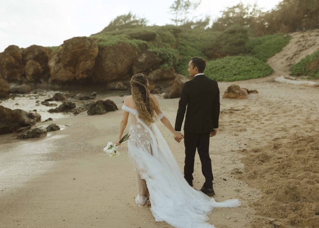 couple walking on the beach for their Kauai elopement 