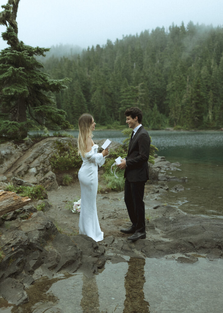 bride and groom reading their vows for their Mowich Lake Elopement in Mt. Rainier National Park 