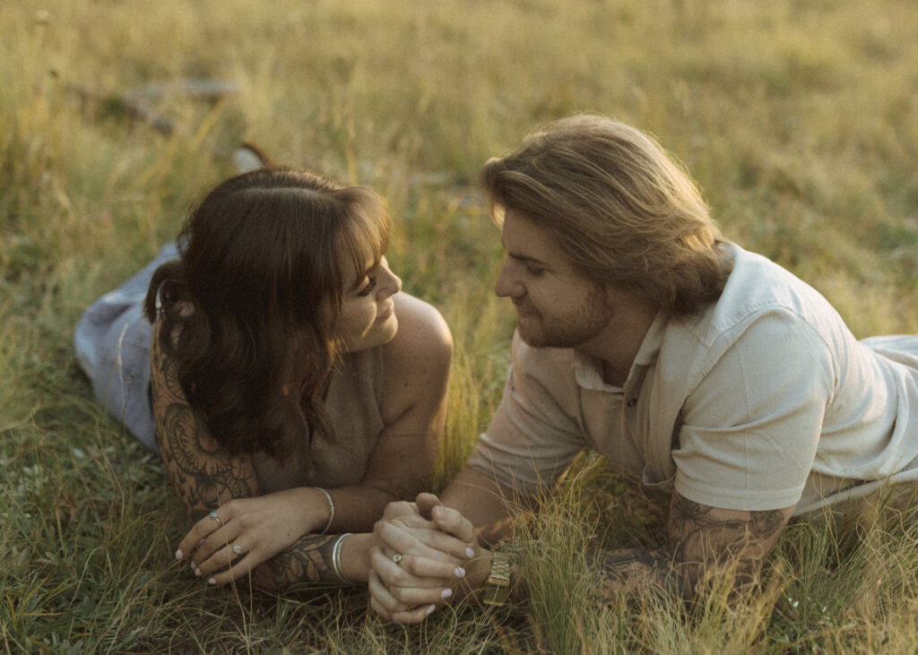 couple laying in the grass for their flagstaff engagement photos