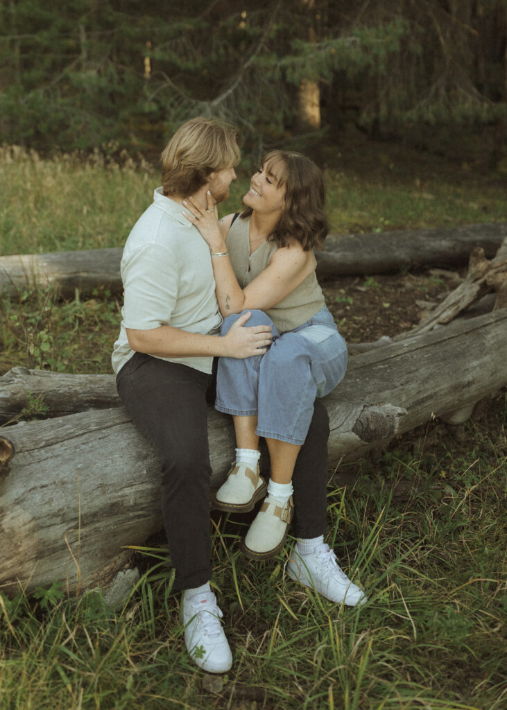 couple sitting on a log for their flagstaff engagement photos