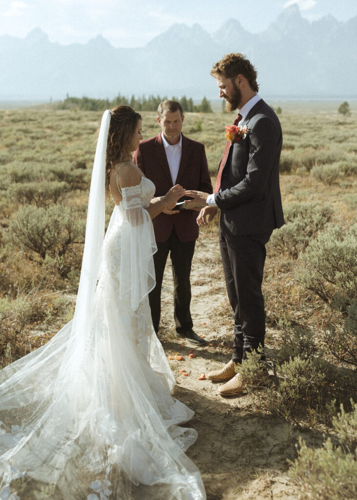 bride and groom exchanging rings for their Teton elopement 