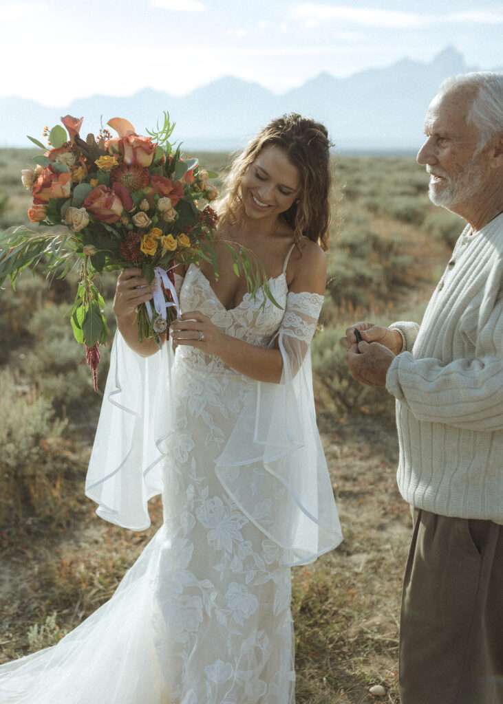 bride showing her grandpa her bouquet in the Grand Tetons 