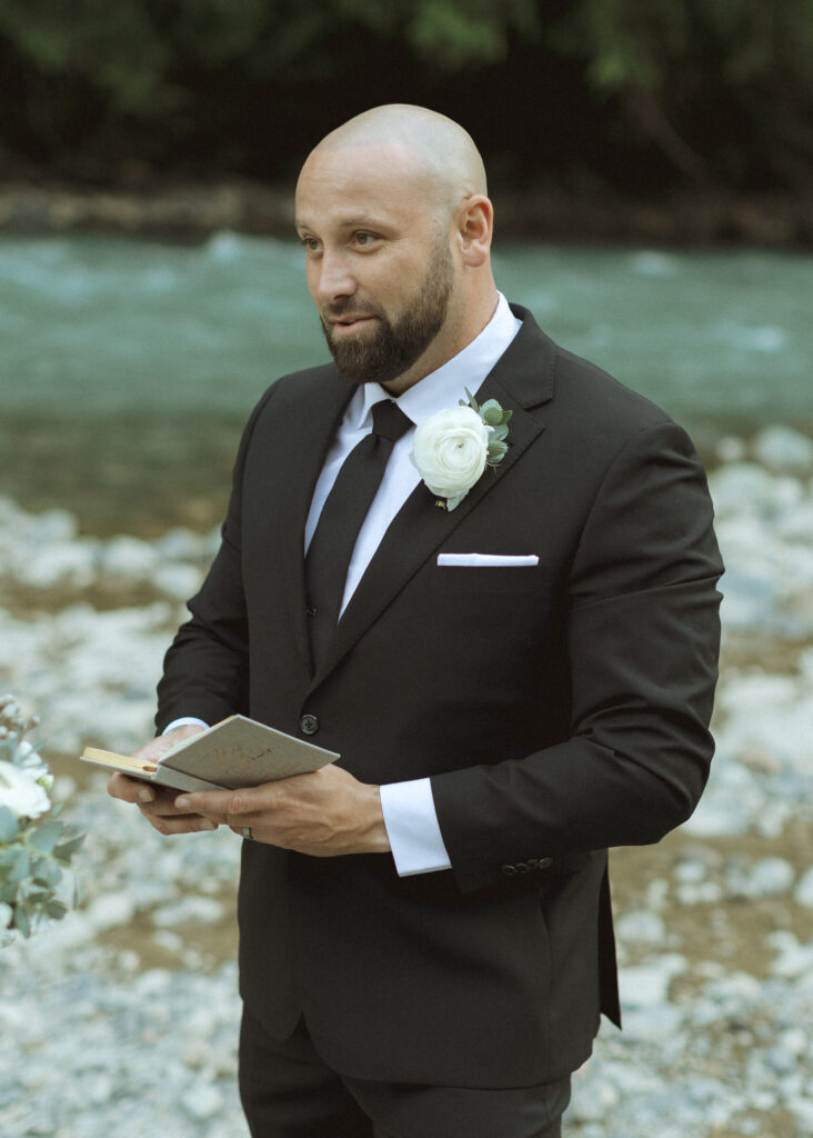 bride and groom reading their vows along the river for their Mount Baker Elopement 