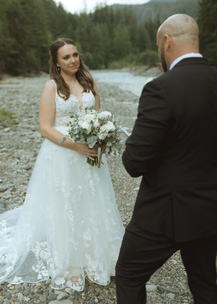 bride and groom reading their vows along the river for their Mount Baker Elopement 