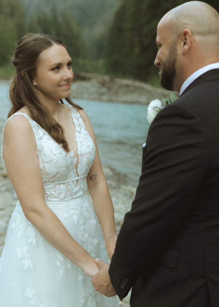 bride and groom reading their vows along the river for their Mount Baker Elopement 