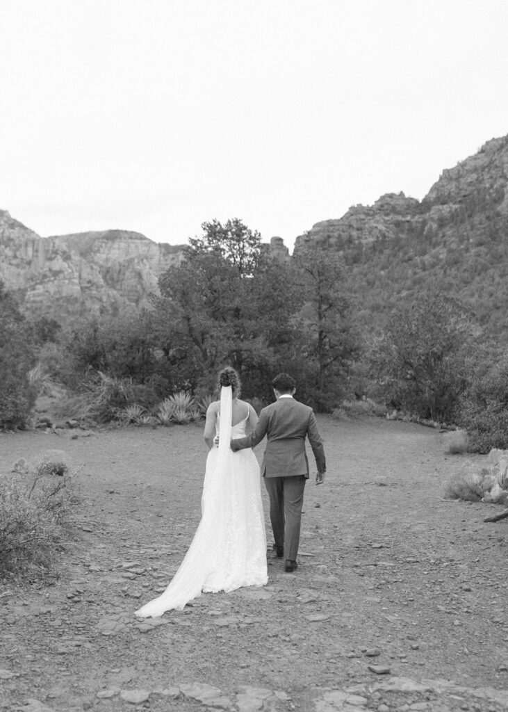 bride and groom walking away in Sedona for photos