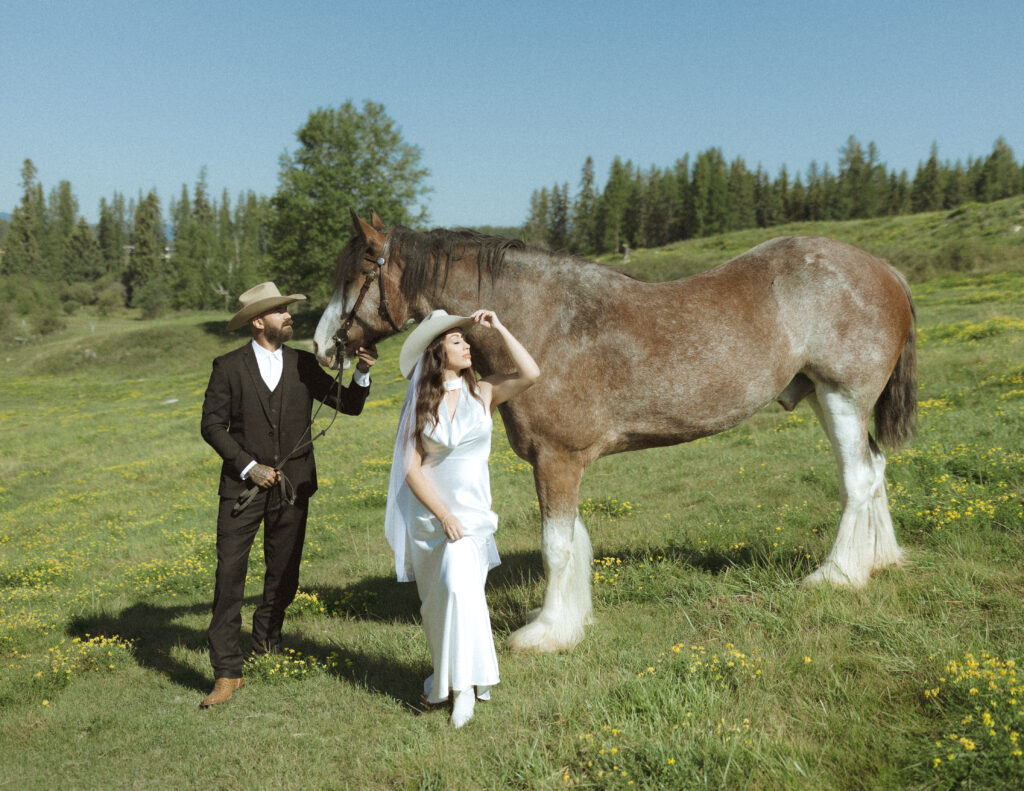 couple taking photos with horses after their lake McDonald elopement