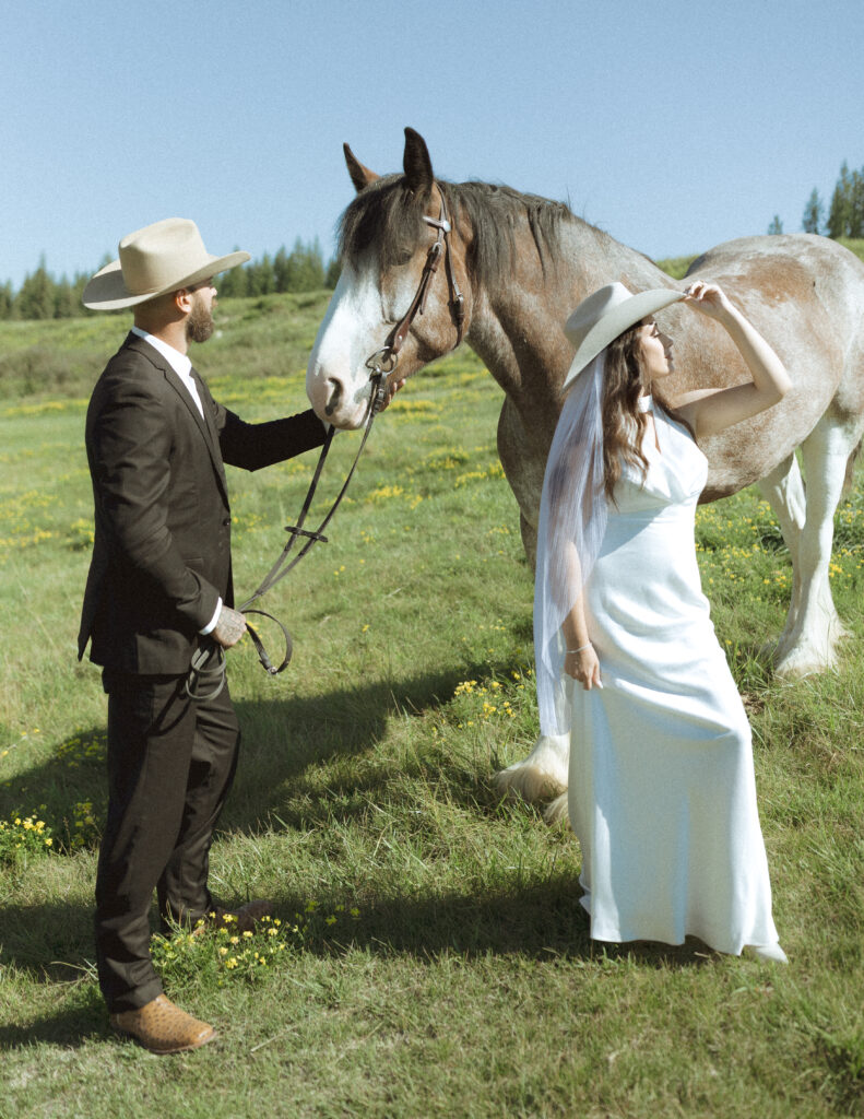 couple taking photos with horses after their lake McDonald elopement