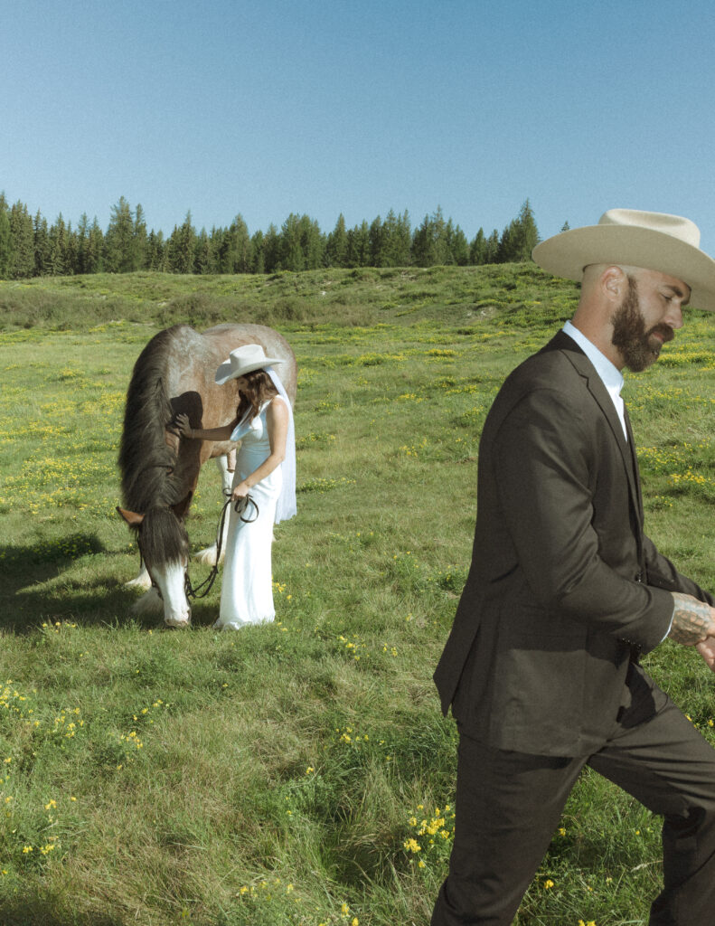 couple taking photos with horses after their lake McDonald elopement