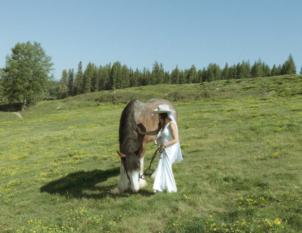 couple taking photos with horses after their lake McDonald elopement